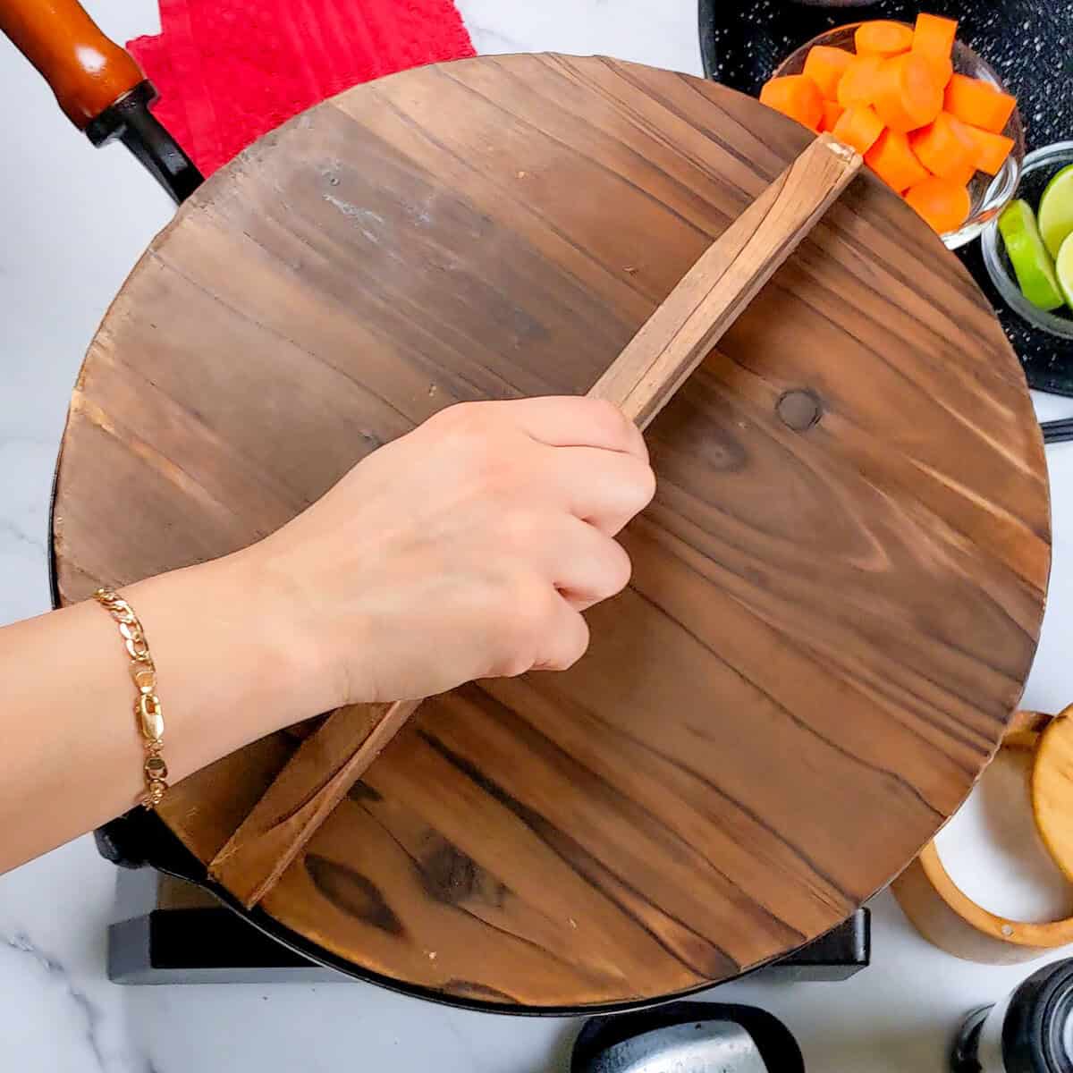 Chopping fresh vegetables for Caribbean Beef Noodle Soup on a wooden cutting board.