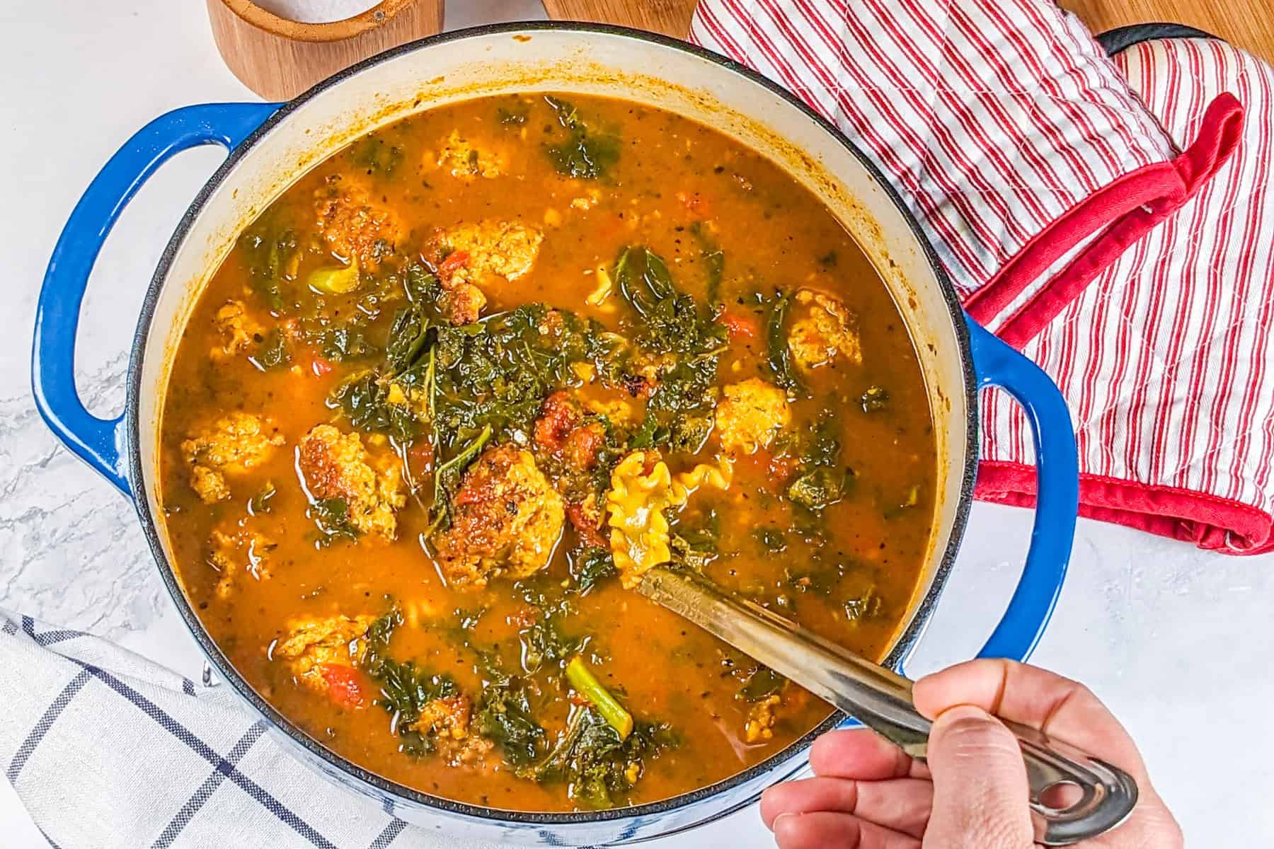 Heart curry turkey meatball soup in a vivid blue lodge cast iron enameled dutch oven.