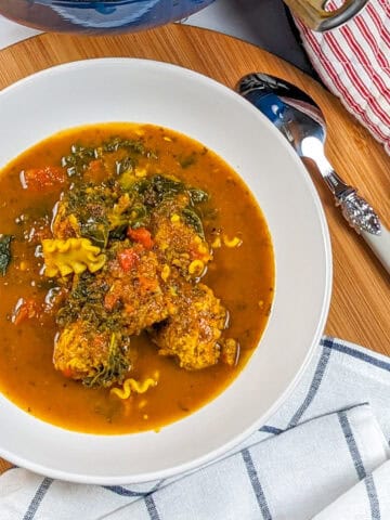 Vibrant curry turkey meatball soup with fresh vegetables and pasta, perfect for comfort.