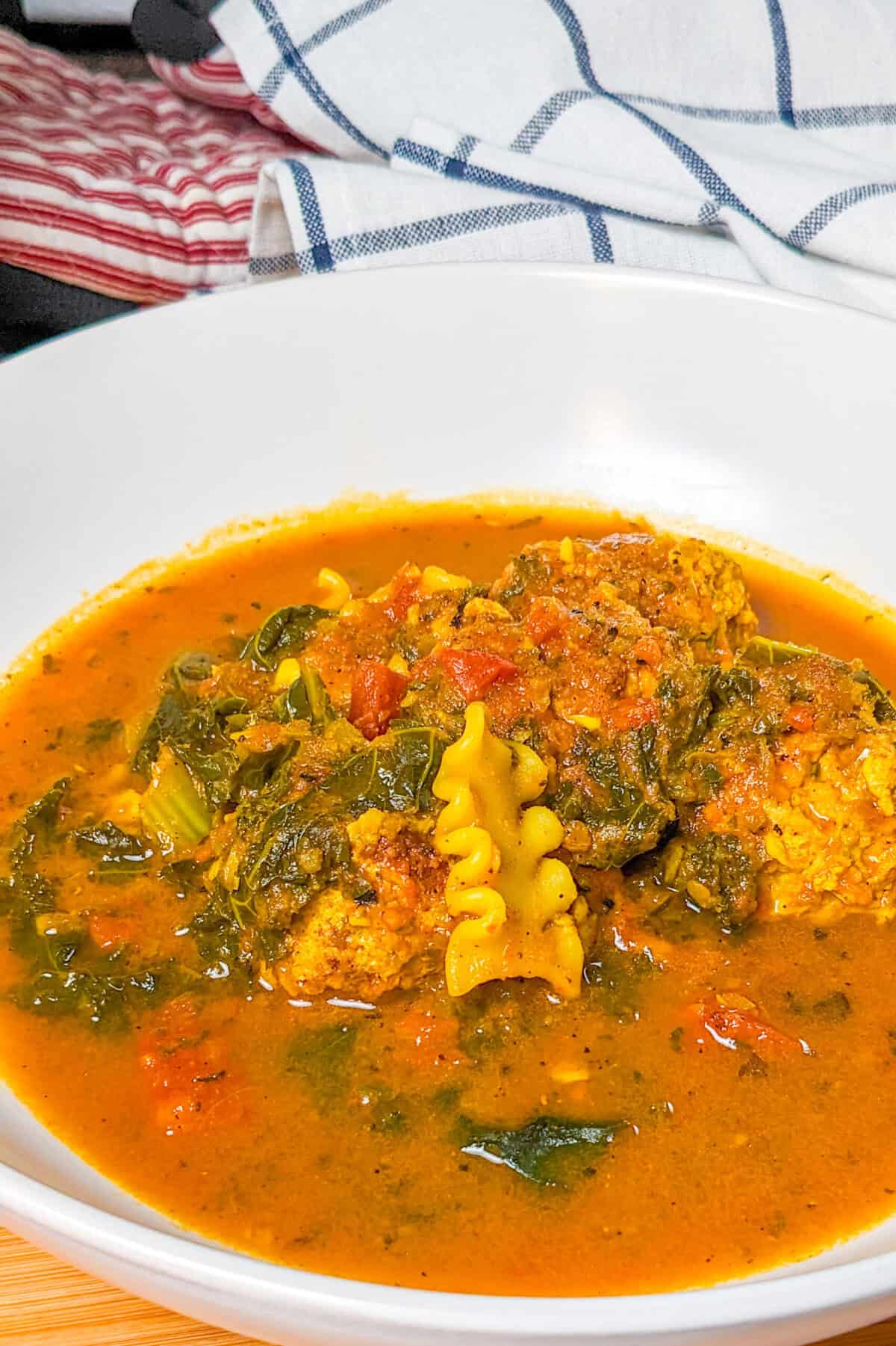 Hearty curry turkey meatball soup with pasta, greens, and vibrant broth, perfect for chilly days.