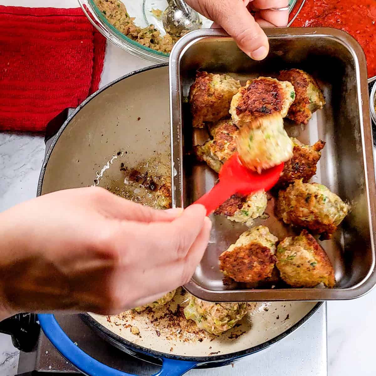 Crispy curry turkey meatballs being transferred from the pan, showcasing delicious cooking techniques.