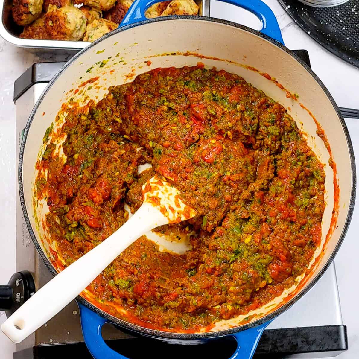 Hearty aromatic paste in a blue cast iron pot.