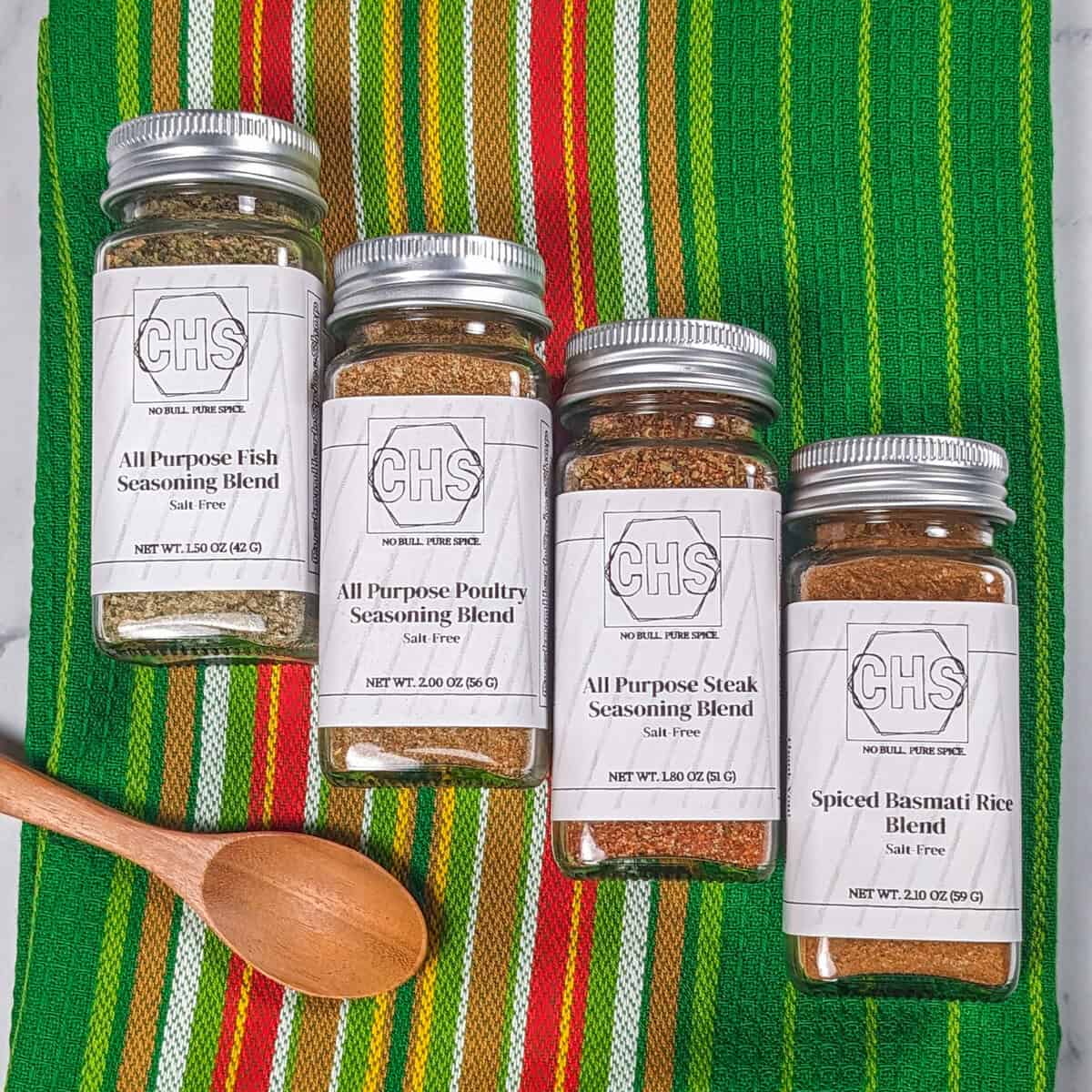 The meal prep bundle from custom herb spice shop, displaying four custom gourmet spice blends: All Purpose Fish Seasoning, All Purpose Poultry Seasoning, All Purpose Steak Seasoning, and Spiced Basmati Rice Blend.