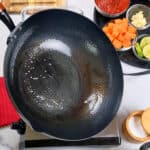 Fresh ingredients ready for cooking in a well-prepared kitchen with a cast iron pan being oiled.