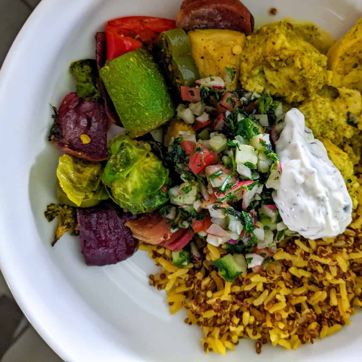 Vibrant plate of spiced brown basmati rice with roasted vegetables and fresh toppings.