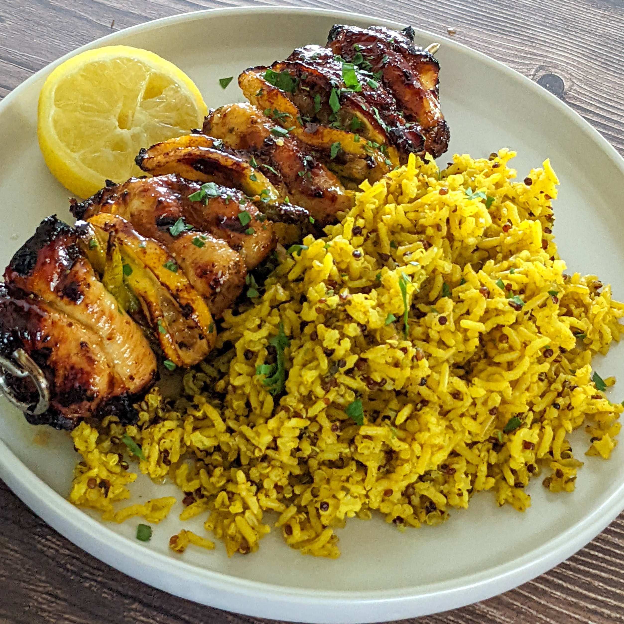 Grilled chicken skewers with yellow rice and lemon, ideal for flavorful meals or gatherings.