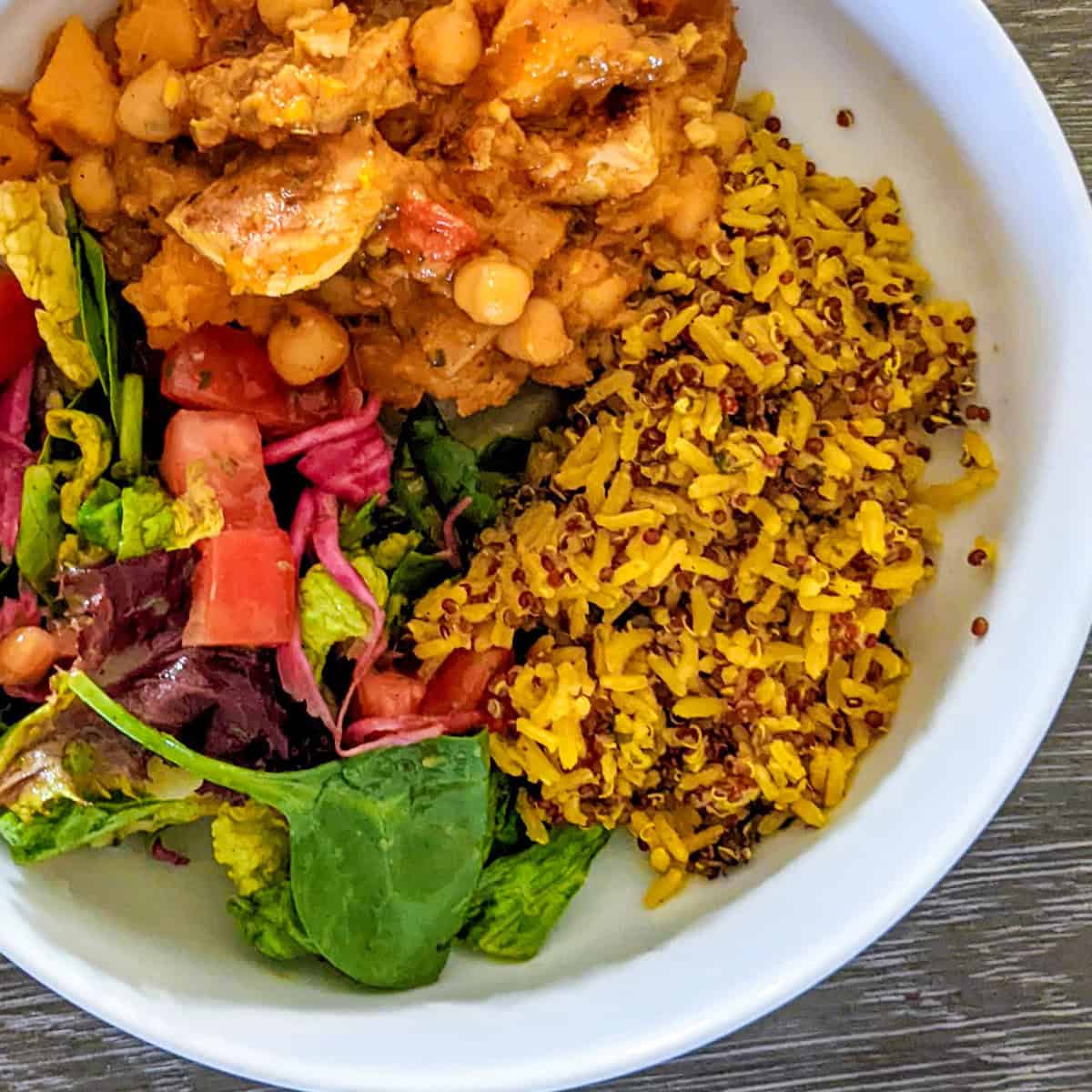 Colorful chickpea curry with fresh salad and turmeric-infused rice in a vibrant bowl.