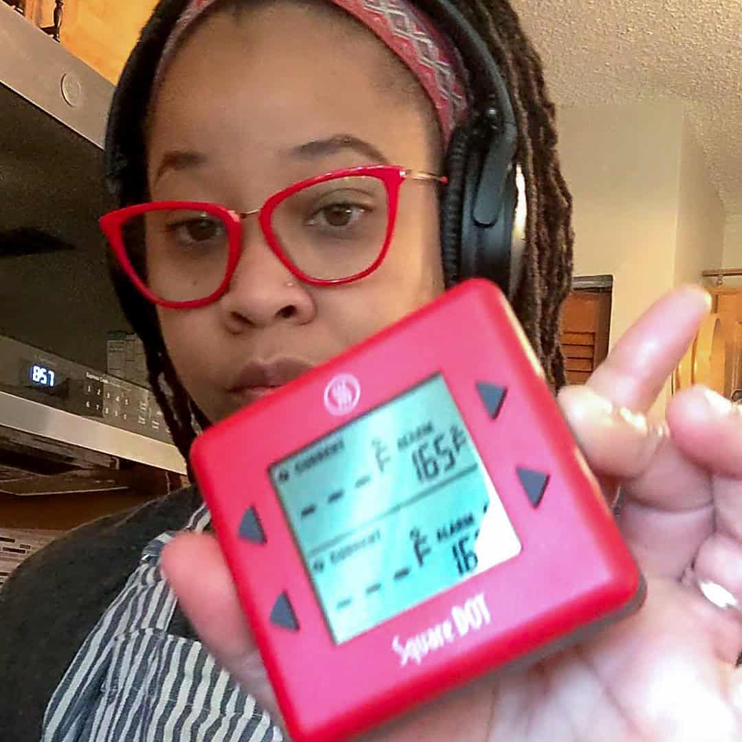 Chef Maika using Thermoworks Dot thermometer in a cozy kitchen, highlighting her cooking passion.