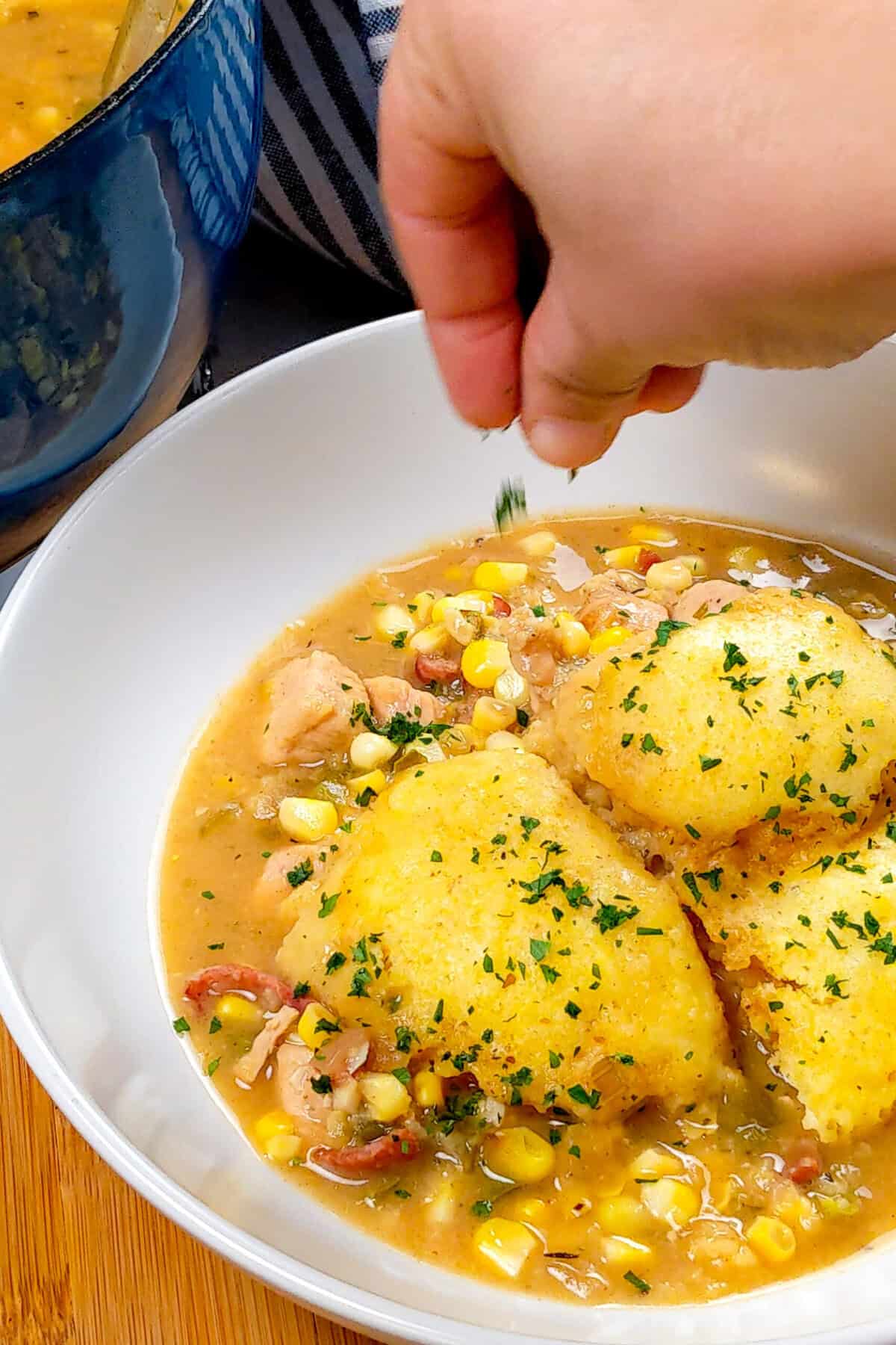 Delicious chicken corn chowder with fluffy dumplings, garnished with fresh herbs for warmth.