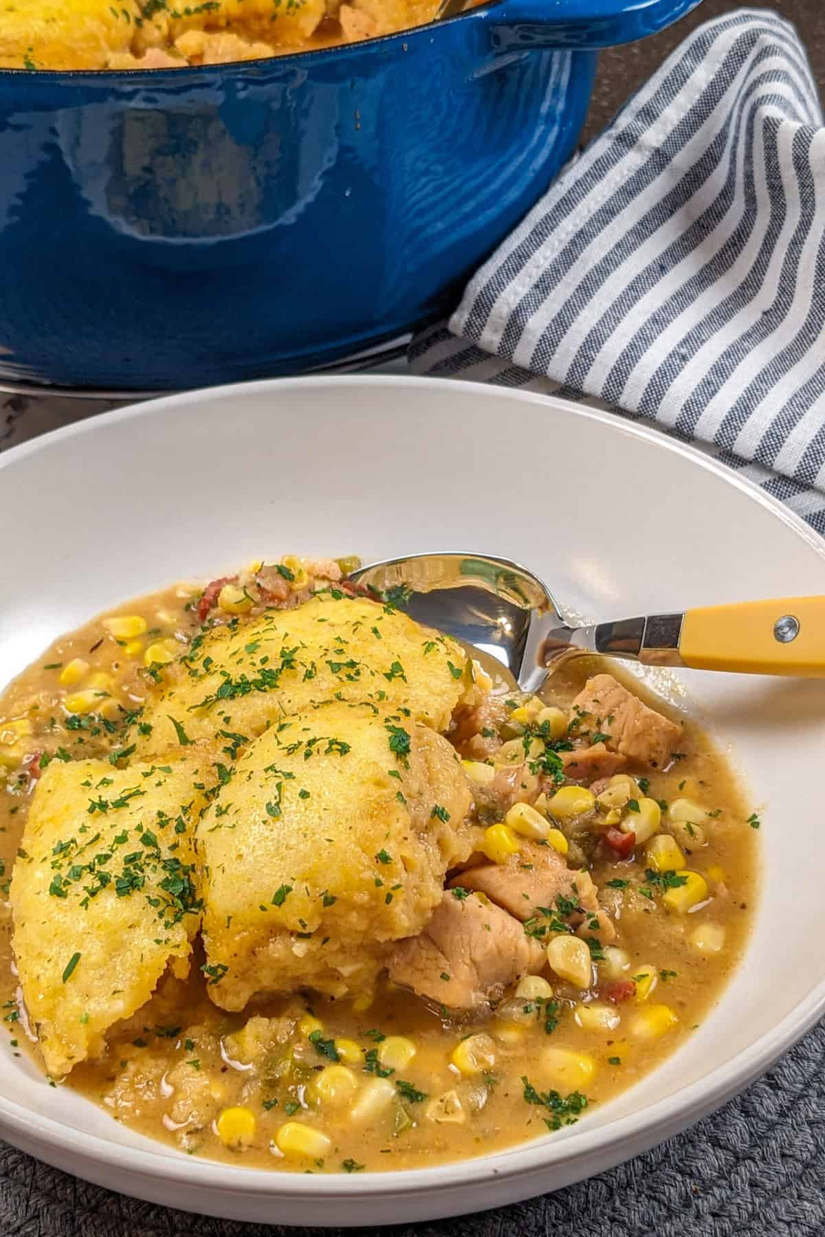 Delicious chicken corn chowder with fluffy dumplings in a rustic bowl, perfect for cozy meals.