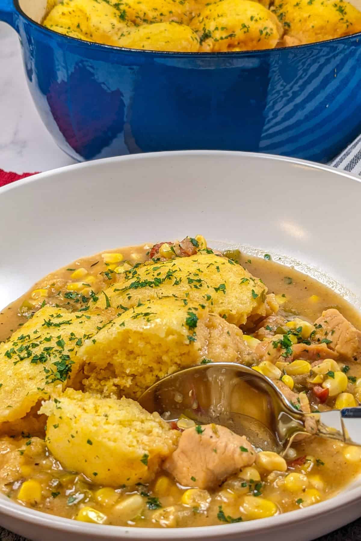 Hearty chicken corn chowder with fluffy dumplings, fresh herbs, and a comforting broth.