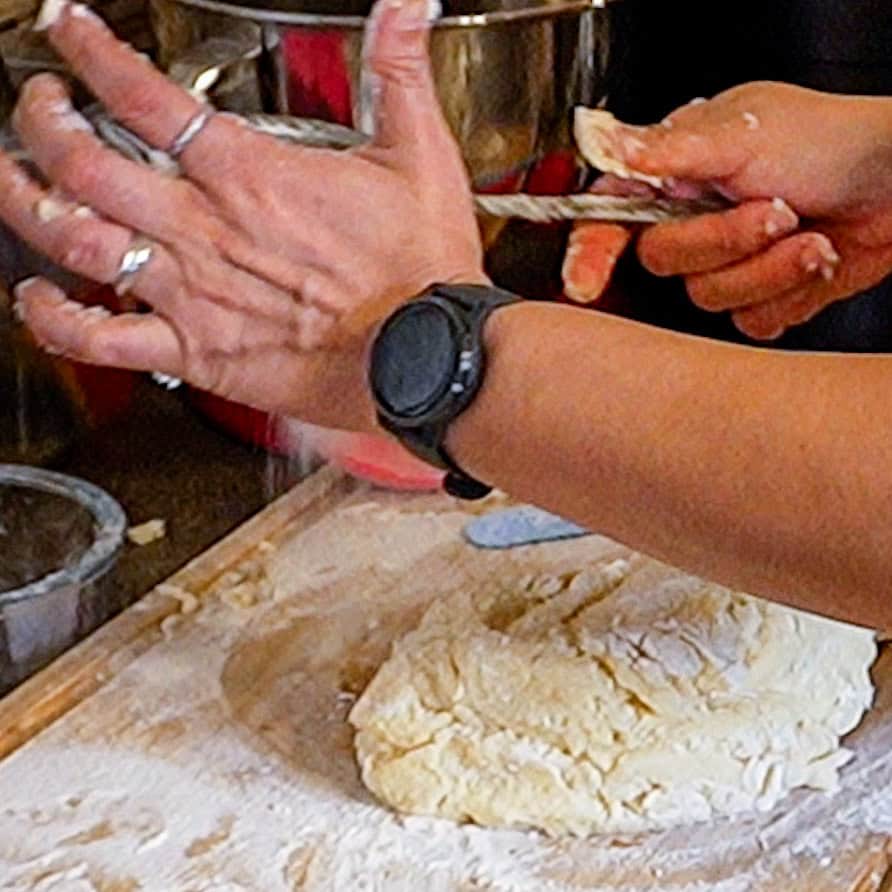 Hands shaping gnocchi dough for a potato gnocchi in a cozy kitchen.