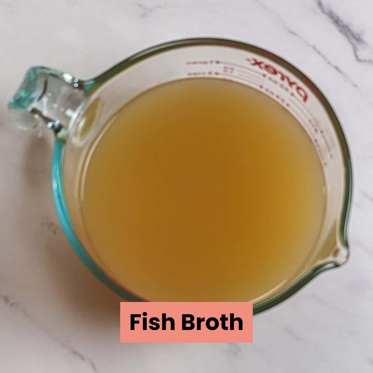 fish broth in a glass pyrex measuring cup.