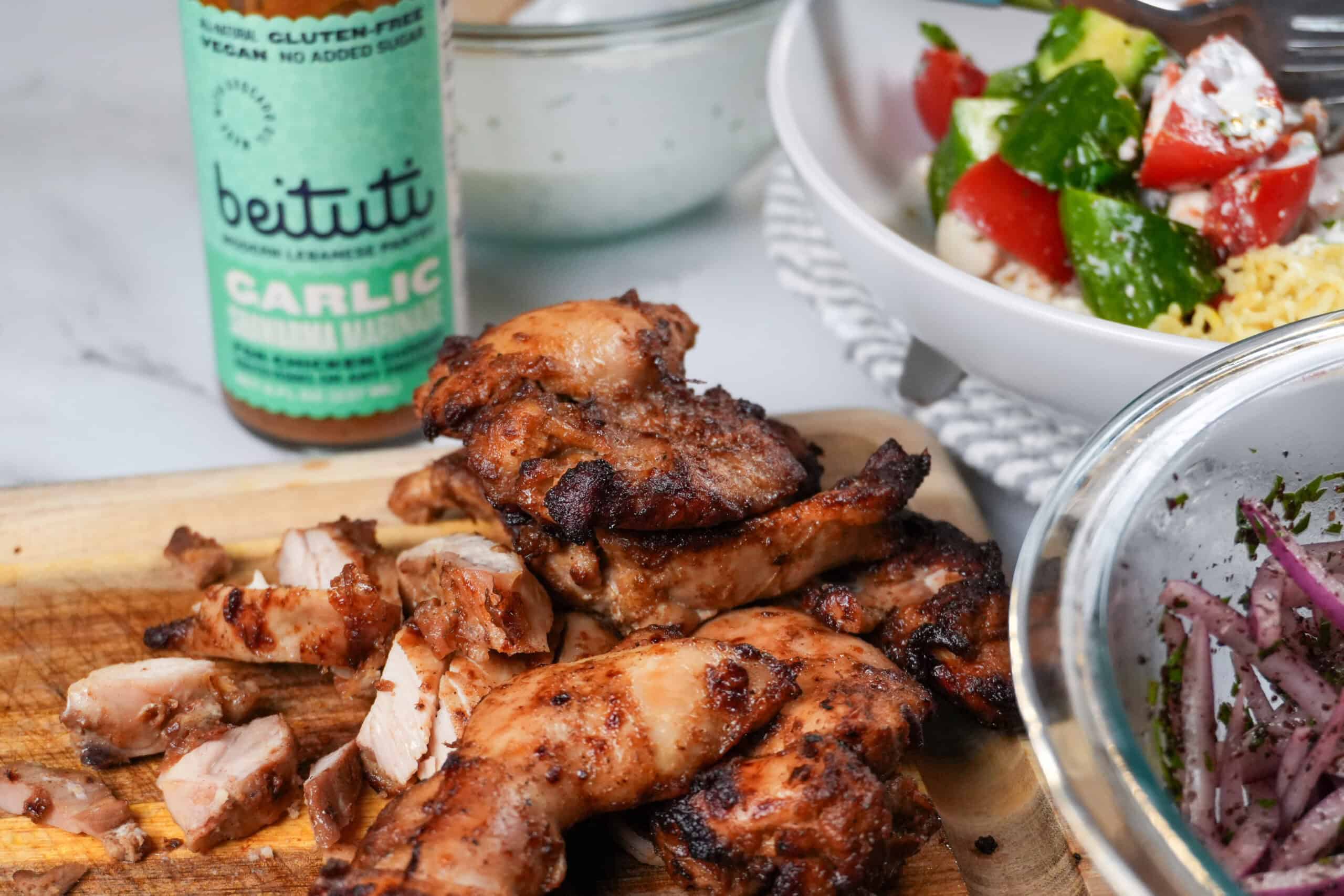 close up of the Beituti Shawarma Chicken Thighs sliced on a cutting board.