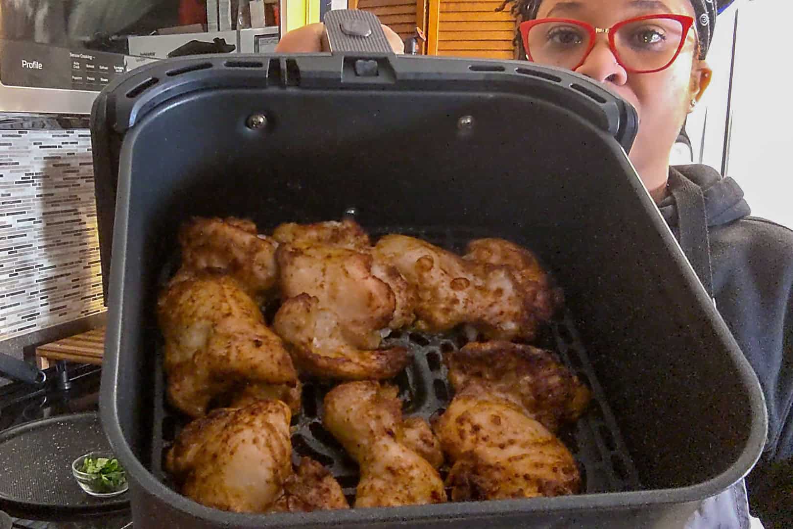 chef maika showcasing a close up of the cooked air fried chicken thighs.