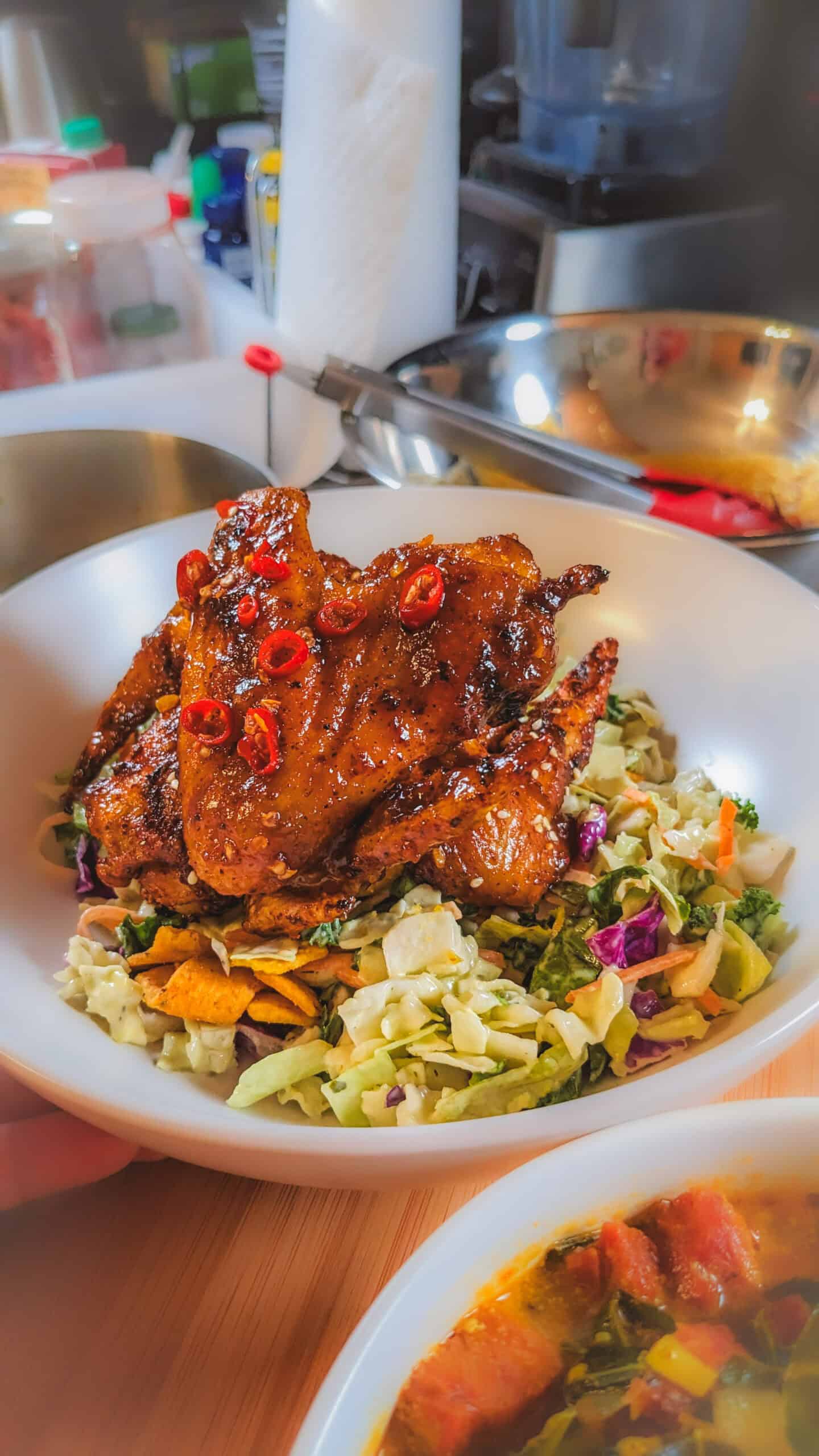 Habanero tamarind glazed chicken wings atop a vibrant salad of crunchy vegetables.