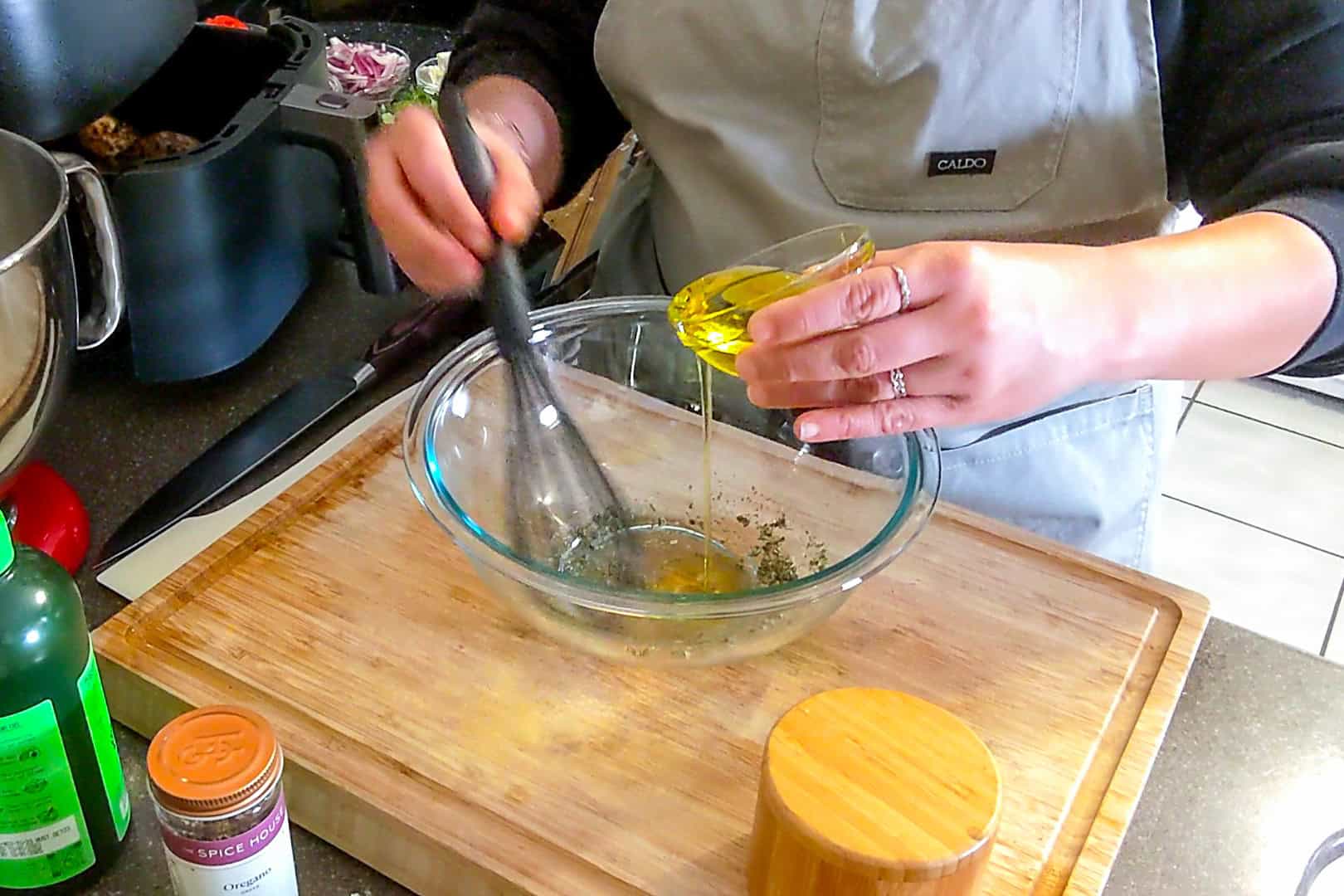 olive oil being drizzled into the dressing ingredients.