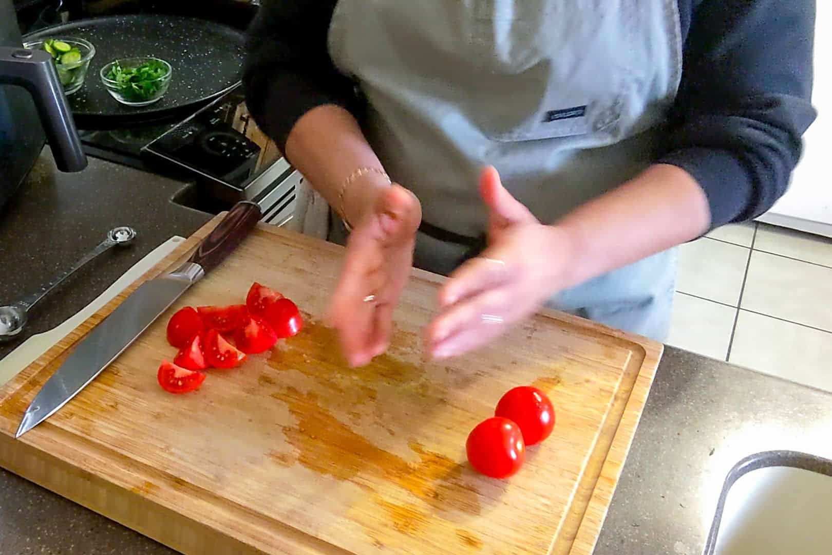 tomatoes on a cutting board separated by whole and quartered.