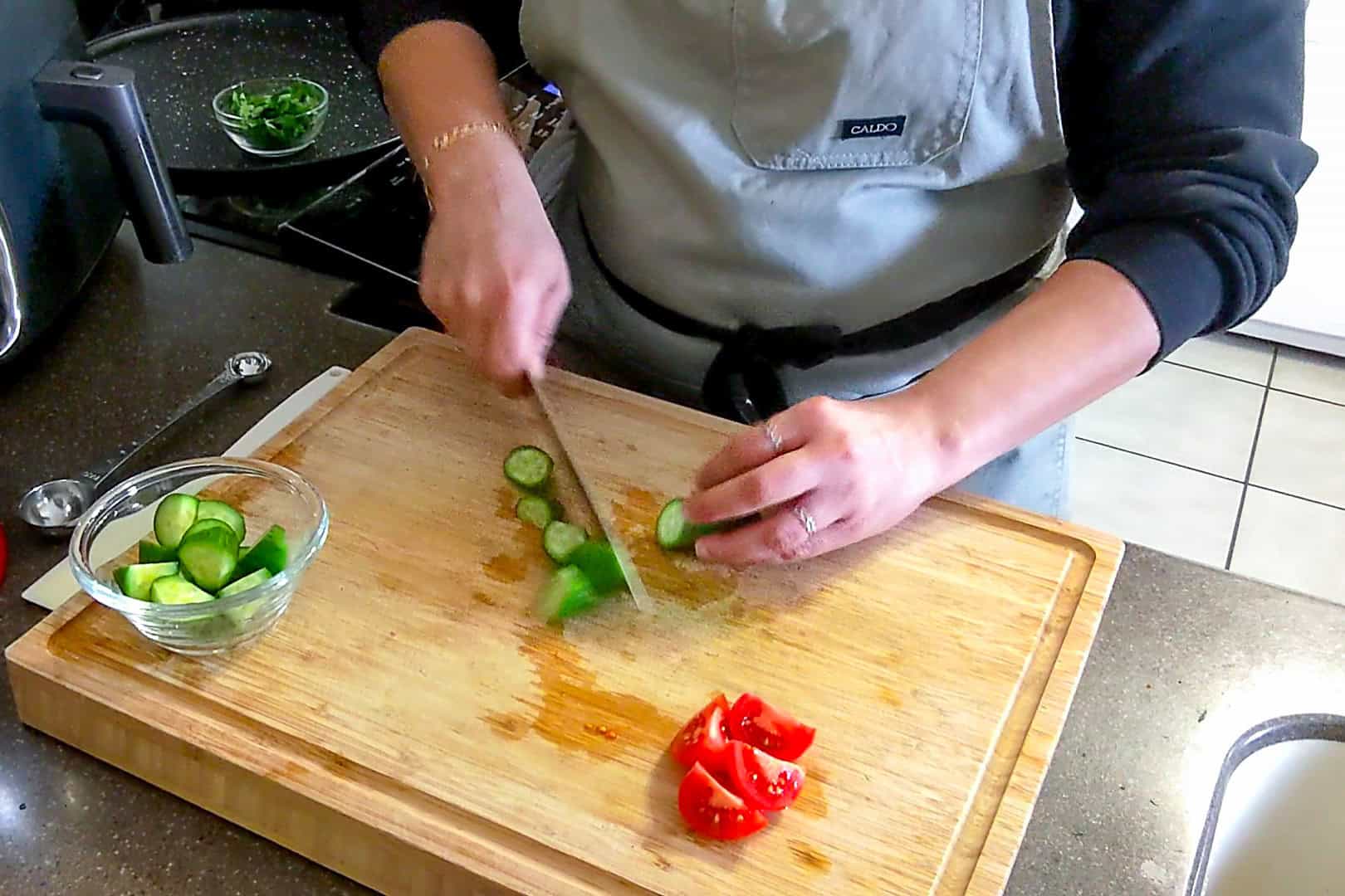 cucumber cut into large chunks on a cutting board.