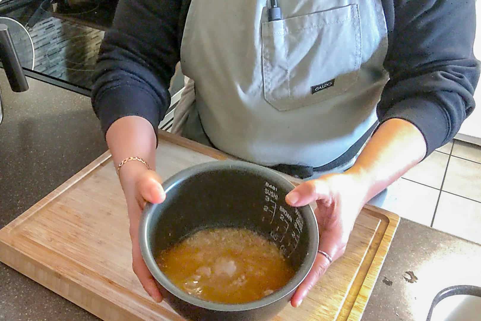 water added to the seasoned rice in the rice cooker's insert.