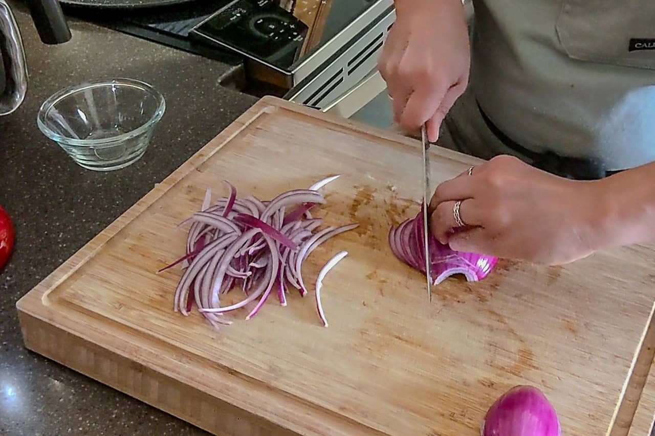 slicing the red onion, this time with the onion faced down.