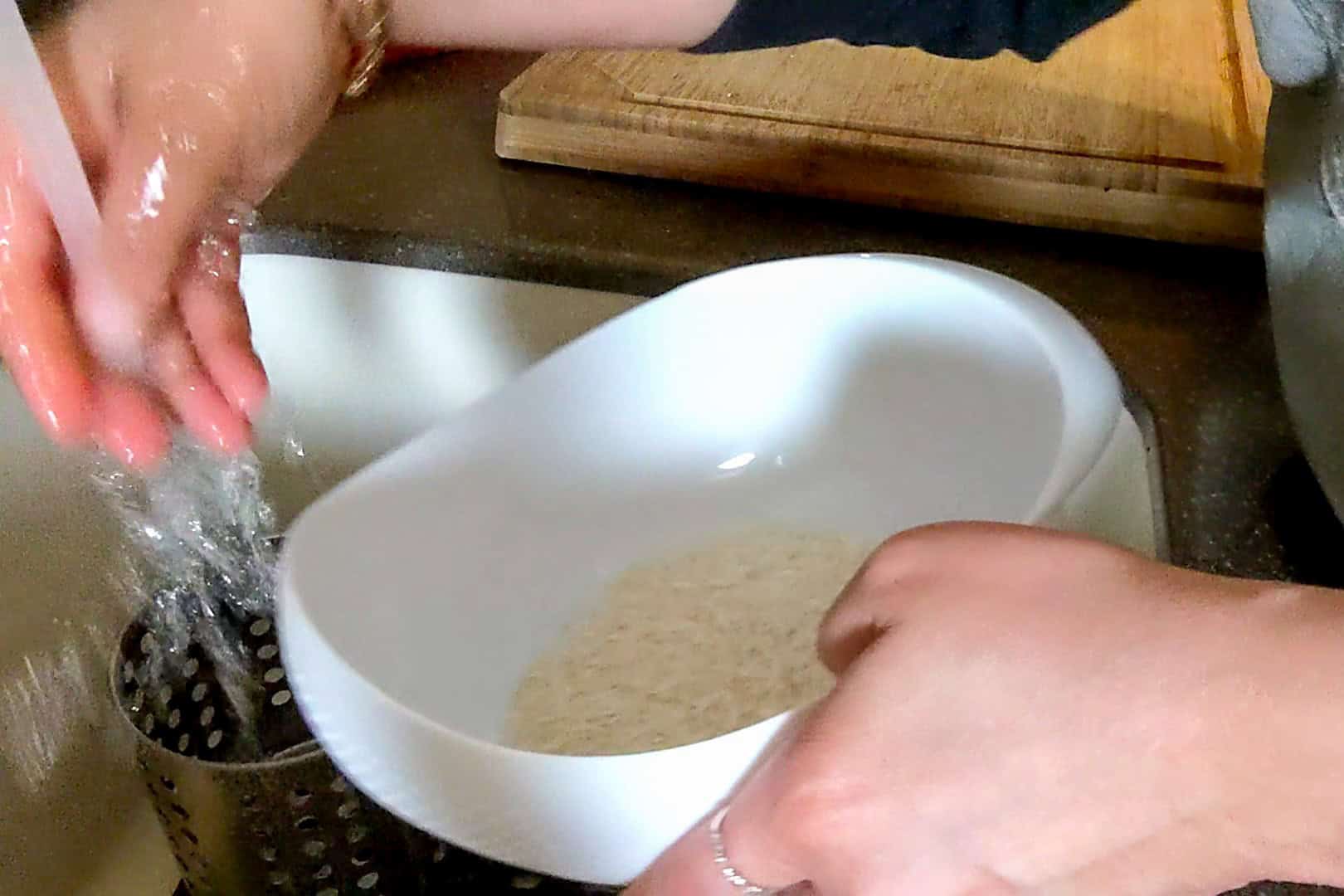 about to rinse rice under water in a rice washer.