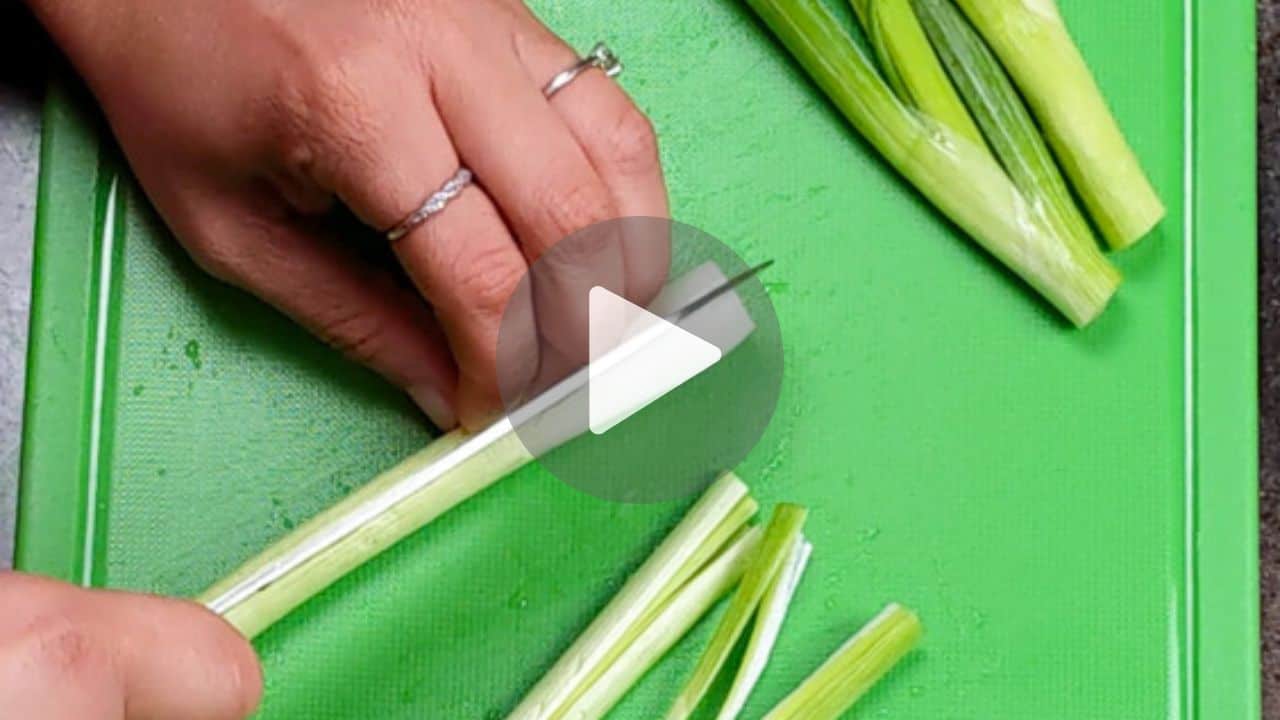 chef maika tucking in her fingers to cut a scallion.