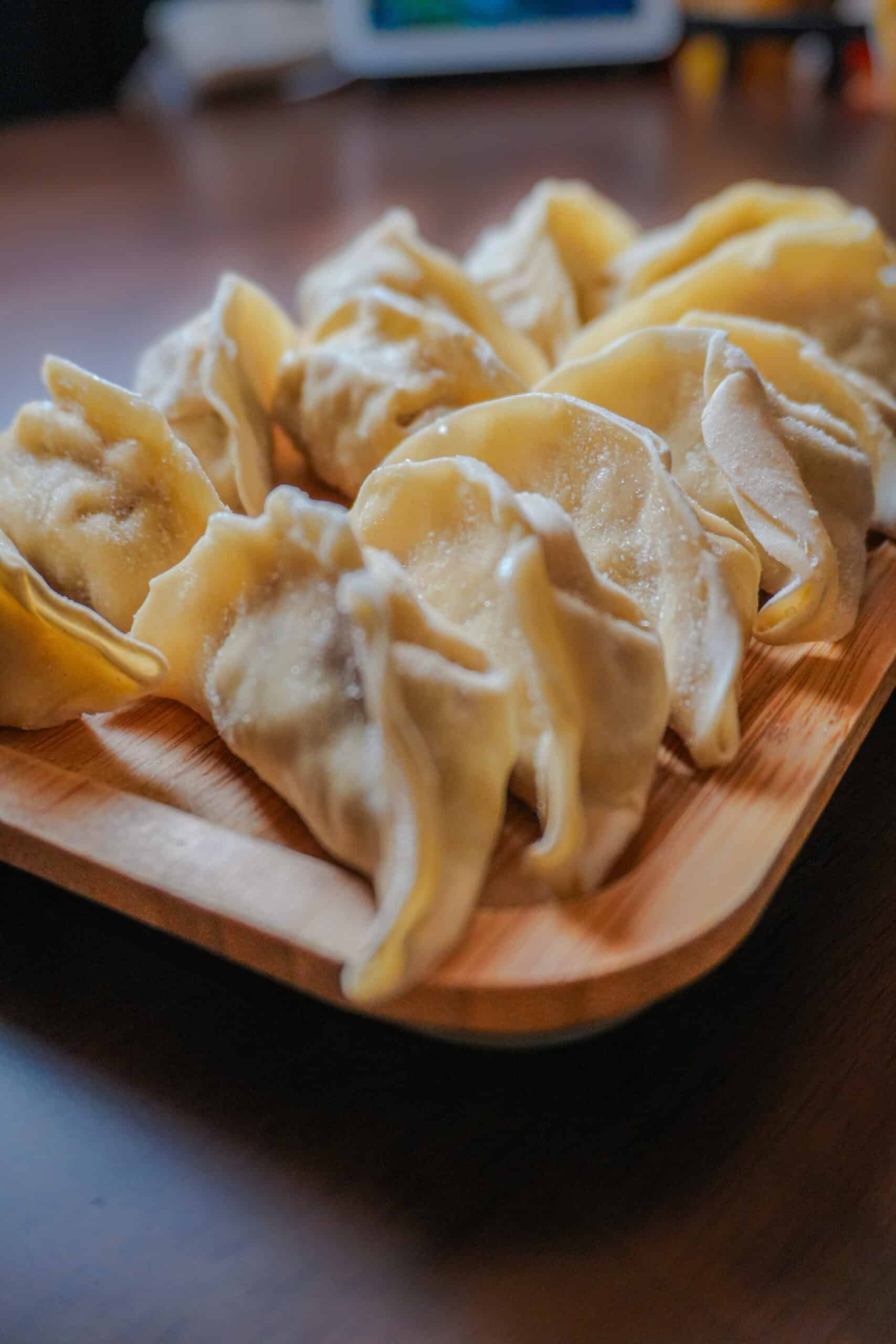 side view of frozen Trader Joe's gyoza potstickers on a wooden plate.